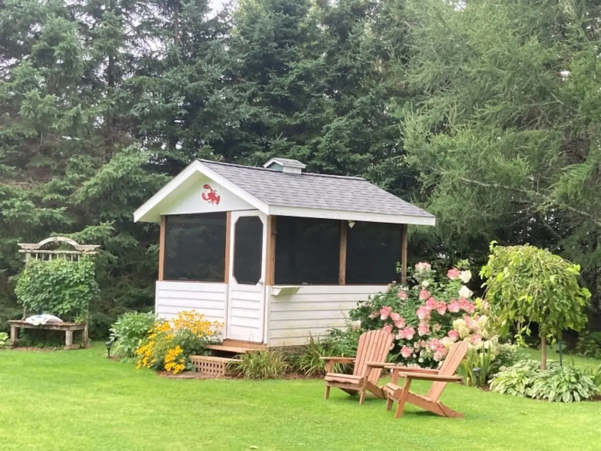 The screened gazebo among the flowers